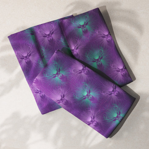 Set of four purple dining napkins featuring alternating teal and violet stag heads with radiating sunburst patterns, sized 18x18 inches.